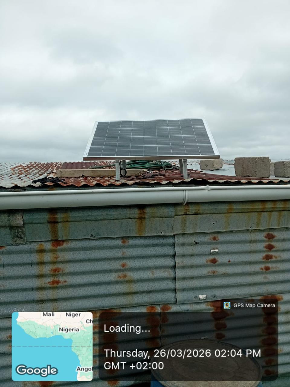 Single solar panel installed above a corrugated roof line.